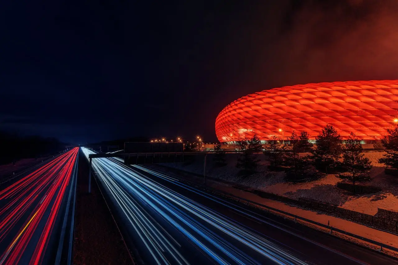 Capture of Allianz Arena illuminated at night with dynamic light trails.